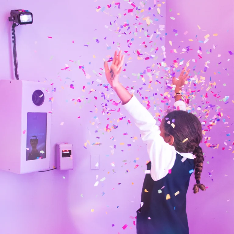 Kid in front of photobooth in pink room